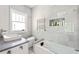 Modern bathroom with gray tile, soaking tub, and a sleek sink with a white cabinet at 307 S Mcdonough St, Decatur, GA 30030