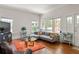 Bright living room with wooden floors, lots of windows, and a grey sectional sofa at 307 S Mcdonough St, Decatur, GA 30030