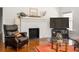 Comfortable living room featuring a brick fireplace, hardwood floors, and a leather armchair at 307 S Mcdonough St, Decatur, GA 30030
