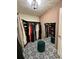 Walk-in closet featuring black built-ins and patterned flooring, illuminated by a stylish light fixture at 544 Magnolia Circle, Palmetto, GA 30268