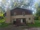 Back exterior view of a beautiful home featuring an outdoor brick chimney and lush trees at 110 Chippewa Ct, Riverdale, GA 30296