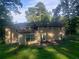 Rear exterior of a two-story house with large windows, patio space, and lush green yard at 110 Chippewa Ct, Riverdale, GA 30296