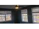 Bedroom with a ceiling fan and three windows overlooking trees and cars at 110 Chippewa Ct, Riverdale, GA 30296