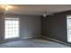 Bedroom with neutral walls, ceiling fan, and two large windows at 110 Chippewa Ct, Riverdale, GA 30296