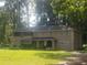 Large two-story home with a covered entry and lush greenery in a serene, wooded setting at 110 Chippewa Ct, Riverdale, GA 30296