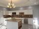 Well-lit kitchen with white cabinetry, gray tiled floors and backsplash, island and stainless steel dishwasher at 110 Chippewa Ct, Riverdale, GA 30296