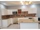 Kitchen featuring white cabinets, stone countertops, stainless steel microwave, and tiled backsplash at 110 Chippewa Ct, Riverdale, GA 30296