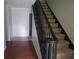 Carpeted stairway with dark wood railing and trim leading to the second floor at 110 Chippewa Ct, Riverdale, GA 30296