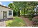 Backyard showing a well-maintained lawn, paver patio, fenced perimeter, door leading to the outside, and mature trees at 1549 Lake Holcomb Ln, Marietta, GA 30062