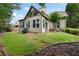 Backyard featuring a well-maintained lawn, mature trees, brick border, and the exterior of the home at 1549 Lake Holcomb Ln, Marietta, GA 30062