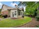 Backyard view featuring a well-kept lawn, a patio, mature trees, and a charming brick border at 1549 Lake Holcomb Ln, Marietta, GA 30062
