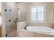 Bathroom featuring soaking tub and glass enclosed shower with tile surround at 1549 Lake Holcomb Ln, Marietta, GA 30062
