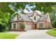 A two-story brick and siding home with a well-manicured lawn, mature trees, and a spacious driveway at 1549 Lake Holcomb Ln, Marietta, GA 30062
