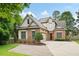Charming two-story brick home with a well-manicured front yard and a spacious driveway on a sunny day at 1549 Lake Holcomb Ln, Marietta, GA 30062