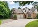 Exterior of a two-story home with brick and siding, complemented by a well-maintained lawn, mature trees, and ample driveway at 1549 Lake Holcomb Ln, Marietta, GA 30062