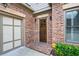 Close-up of the brick facade, arched entryway, and dark wood front door, adding architectural interest to this home at 1549 Lake Holcomb Ln, Marietta, GA 30062