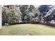 Large, grassy backyard offers ample space and a peaceful setting with mature trees at 3001 Donamire Nw Ave, Kennesaw, GA 30144