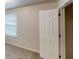 Neutral painted bedroom with a window and an open entry door at 3001 Donamire Nw Ave, Kennesaw, GA 30144