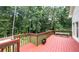 Expansive back deck overlooks wooded yard and features red stained wood and a bench at 6945 John Rivers Rd, Fairburn, GA 30213