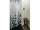 Bathroom featuring decorative floral shower curtain, cross decor, and side table at 6945 John Rivers Rd, Fairburn, GA 30213