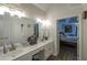 Bathroom boasts a dual vanity, well-lit mirror, and an open doorway leading into the main bedroom at 6945 John Rivers Rd, Fairburn, GA 30213