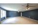 Expansive, carpeted bonus room featuring large windows and well-lit ceiling fans enhancing the ambiance at 6945 John Rivers Rd, Fairburn, GA 30213