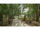 Private gated entrance with stone pillars and lush landscaping along the driveway at 6945 John Rivers Rd, Fairburn, GA 30213