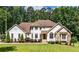 Charming two-story home with landscaped yard on a lush lot featuring a combination of stucco and stone facade at 6945 John Rivers Rd, Fairburn, GA 30213