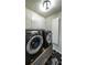 Well-lit laundry room showcasing a modern, dark-colored Samsung washer and dryer with white storage cabinets at 6945 John Rivers Rd, Fairburn, GA 30213