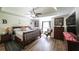 Bedroom featuring tray ceiling, hardwood floors, and french doors leading to ensuite bathroom at 6945 John Rivers Rd, Fairburn, GA 30213