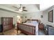 Bedroom with wooden furniture, tray ceiling, and access to ensuite bathroom via french doors at 6945 John Rivers Rd, Fairburn, GA 30213