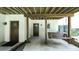 This covered porch has a swing, two exterior doors, and concrete flooring at 6945 John Rivers Rd, Fairburn, GA 30213