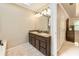 Bright bathroom with double vanity, granite counters, a large mirror and neutral tile flooring at 910 Kings Arms Way, Johns Creek, GA 30022