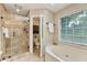 Well-lit bathroom featuring a glass shower, and separate toilet room with natural light from a window at 910 Kings Arms Way, Johns Creek, GA 30022
