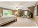 Bedroom featuring neutral colors, carpet flooring, a ceiling fan, and many windows for natural light at 910 Kings Arms Way, Johns Creek, GA 30022