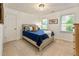 Cozy bedroom with carpet flooring, two windows for natural light, and a comfortable bed with throw pillows at 910 Kings Arms Way, Johns Creek, GA 30022