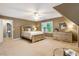 Spacious bedroom with carpet, light neutral paint, ceiling fan, and a view of the staircase at 910 Kings Arms Way, Johns Creek, GA 30022