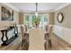 Elegant dining room with a dark wood table, upholstered chairs, and a view of the backyard at 910 Kings Arms Way, Johns Creek, GA 30022