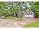 Stately traditional home boasts a sprawling driveway, attached garage and mature landscaping at 910 Kings Arms Way, Johns Creek, GA 30022