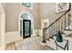 Elegant foyer with a black front door, staircase, and modern decor at 910 Kings Arms Way, Johns Creek, GA 30022