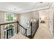 Upstairs hallway with chandelier, leading to bedrooms and other living spaces, plus a view of the front door at 910 Kings Arms Way, Johns Creek, GA 30022