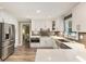 Modern kitchen with white cabinets, stainless steel appliances, gray backsplash, and wood floors at 910 Kings Arms Way, Johns Creek, GA 30022