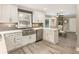 Well-lit kitchen with white cabinets, stainless steel appliances, and a cozy breakfast nook at 910 Kings Arms Way, Johns Creek, GA 30022