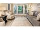 Bright living room featuring a bay window, cozy seating, and natural light at 910 Kings Arms Way, Johns Creek, GA 30022