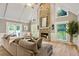 Inviting living room featuring vaulted ceilings, a stone fireplace, and lots of natural light from large windows at 910 Kings Arms Way, Johns Creek, GA 30022