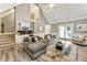 Spacious living room with a high ceiling, wet bar, fireplace, and cozy seating area at 910 Kings Arms Way, Johns Creek, GA 30022