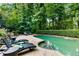 Private in-ground pool surrounded by lush landscaping and lounge chairs on a stone patio at 910 Kings Arms Way, Johns Creek, GA 30022