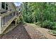 Backyard view showing stairs leading to the deck, landscaping, and a lush, green yard at 1019 Wolf Springs Ct, Lawrenceville, GA 30043