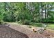 Landscaped backyard with mulched garden, stone decorations, and lush greenery at 1019 Wolf Springs Ct, Lawrenceville, GA 30043