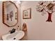 Charming powder room with elegant mirror and decorative wall art at 1019 Wolf Springs Ct, Lawrenceville, GA 30043